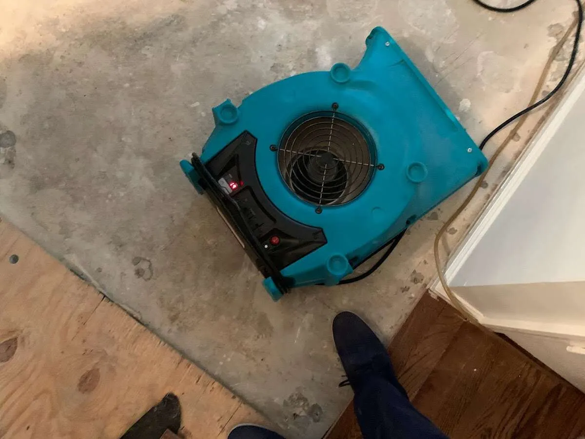 Air mover drying subfloor during Commercial Water Damage Restoration in Wauwatosa